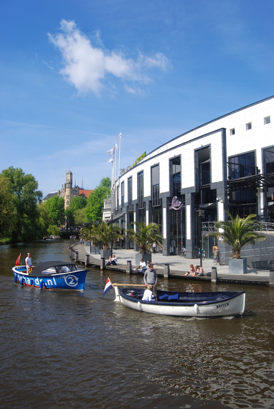 30 - View along the Singelgracht canal in Amsterdam, specifically featuring the Holland Casino Amsterdam Centrum building and the Grand Café Lido